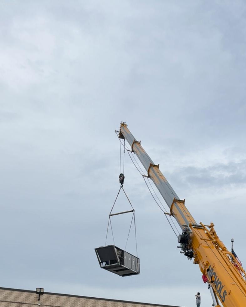 A crane lifts a unit
